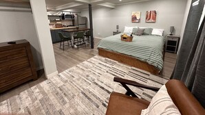 Een moderne slaapkamer met een groot bed, een bureau en een zithoek.