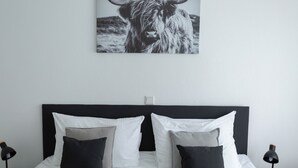 A neatly made bed with white and gray bedding, a black headboard, and a black lamp on each side. - BEST STAY: CITYAPPARTMENT in Hünfeld, WLAN, SmartTV, balcony, central & quiet (Hünfeld)