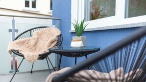 A balcony with wicker chairs, a small table, and a potted plant. - BEST STAY: CITYAPPARTMENT in Hünfeld, WLAN, SmartTV, balcony, central & quiet (Hünfeld)