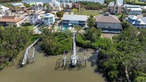 An aerial view of a coastal residential area with houses, a dock, and a marina. - Beachside Retreat: 2BD/2BA Gym + Boat Lift + SHARED Pool! (Fort Myers Beach)