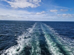 Une vue sur l’océan, avec la vague laissée par le passage d’un navire.
