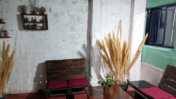 A cozy seating area with a wooden bench, a small table, and a potted plant. - LODGING NAOMI VILLA UNIÓN PROVINCE OF LA RIOJA  (Villa Unión)