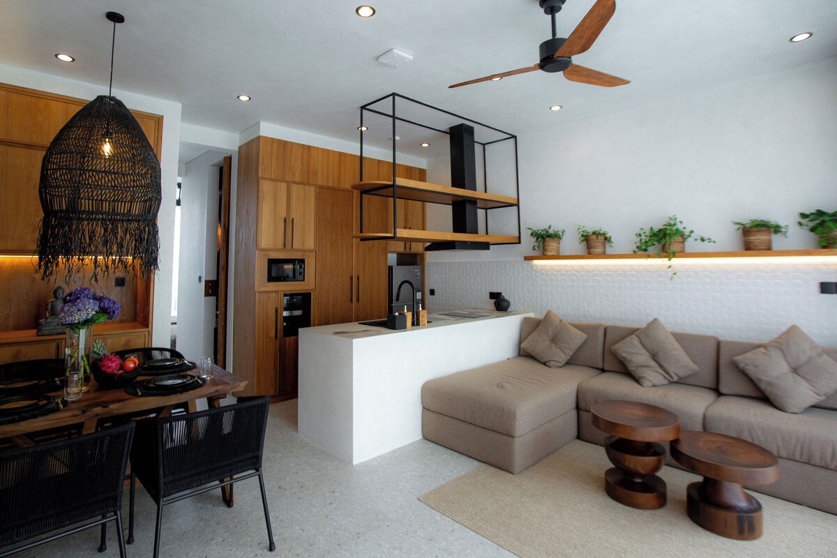 Eine moderne Küche mit Holzausstattung, einer zentralen Kochinsel und einem Essbereich mit Tisch und Stühlen.