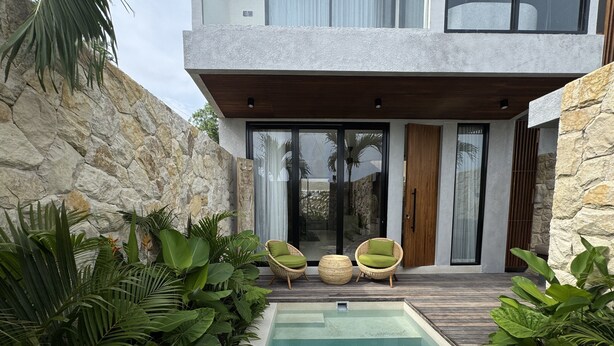 A modern house with a swimming pool, stone walls, and tropical plants. - Rahya Villas Complex (Kutuh)