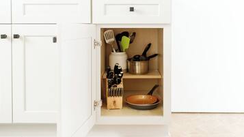 A kitchen cabinet with a built-in spice rack and utensil holder.