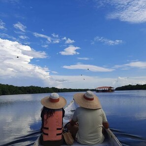 Two people in a boat with a water body and a distant structure. - Hotel Colombia del Golfo (Tolú)