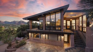 A modern two-story house with large windows, a balcony, and a view of the mountains. - Endless RedRock Views Modern Uptown Home w/Spa/Gym (Sedona)