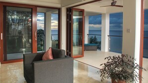 A spacious living area with a sliding glass door leading to a balcony with a pool. - Dream Caribbean Sea View Luxurious  Apartment, Marigot, Saint Lucia (Castries)