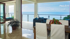 A spacious balcony with a view of the ocean, a dining area with chairs and a table, and a potted plant. - Dream Caribbean Sea View Luxurious  Apartment, Marigot, Saint Lucia (Castries)