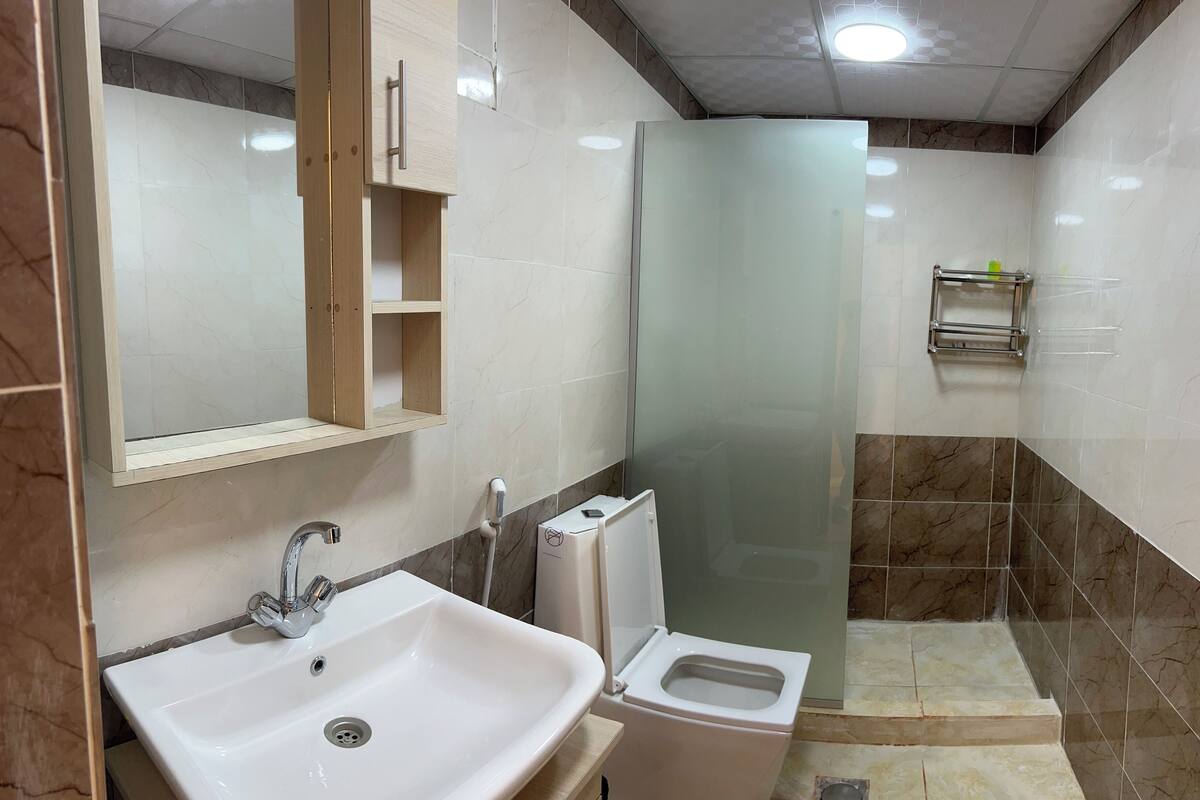 A bathroom with a sink, toilet, and shower.