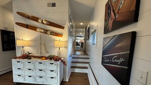 A hallway with a white dresser, a wooden boat decoration, and a 'Chief's Craft' sign.