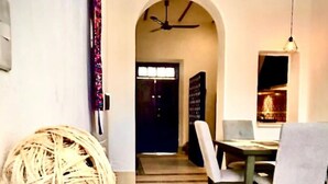 A dining area with a round woven ball, a patterned rug, and a ceiling fan. - Casa Tiago - Downtown & Romance by LAHOS (Mérida)