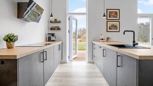 A modern kitchen with a central island, pendant lighting, and a view to the outdoors. - 4 bedroom awesome home in Slagelse (Slagelse)