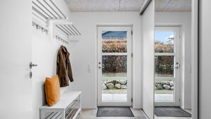 A modern entryway with a bench, coat rack, and a door with a view of the outdoors. - 4 bedroom awesome home in Slagelse (Slagelse)