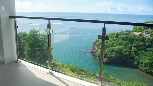 Un balcón con vista despejada a la costa, que incluye agua y vegetación.