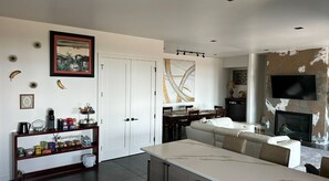 Un salon moderne comprenant un canapé, une table à manger et un coin cuisine avec des placards et des appareils électroménagers.