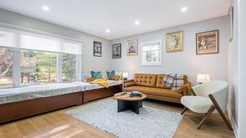 Ein modernes Wohnzimmer mit einer Couch, einem runden Couchtisch und einer Fensterbank.