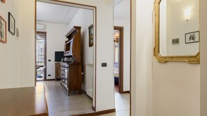 Un pasillo con una mesa de madera, una zona de cocina con estufa y un espejo en la pared.