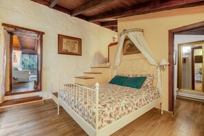 Un dormitorio con una cama, una escalera, un mapa en la pared y un espejo.