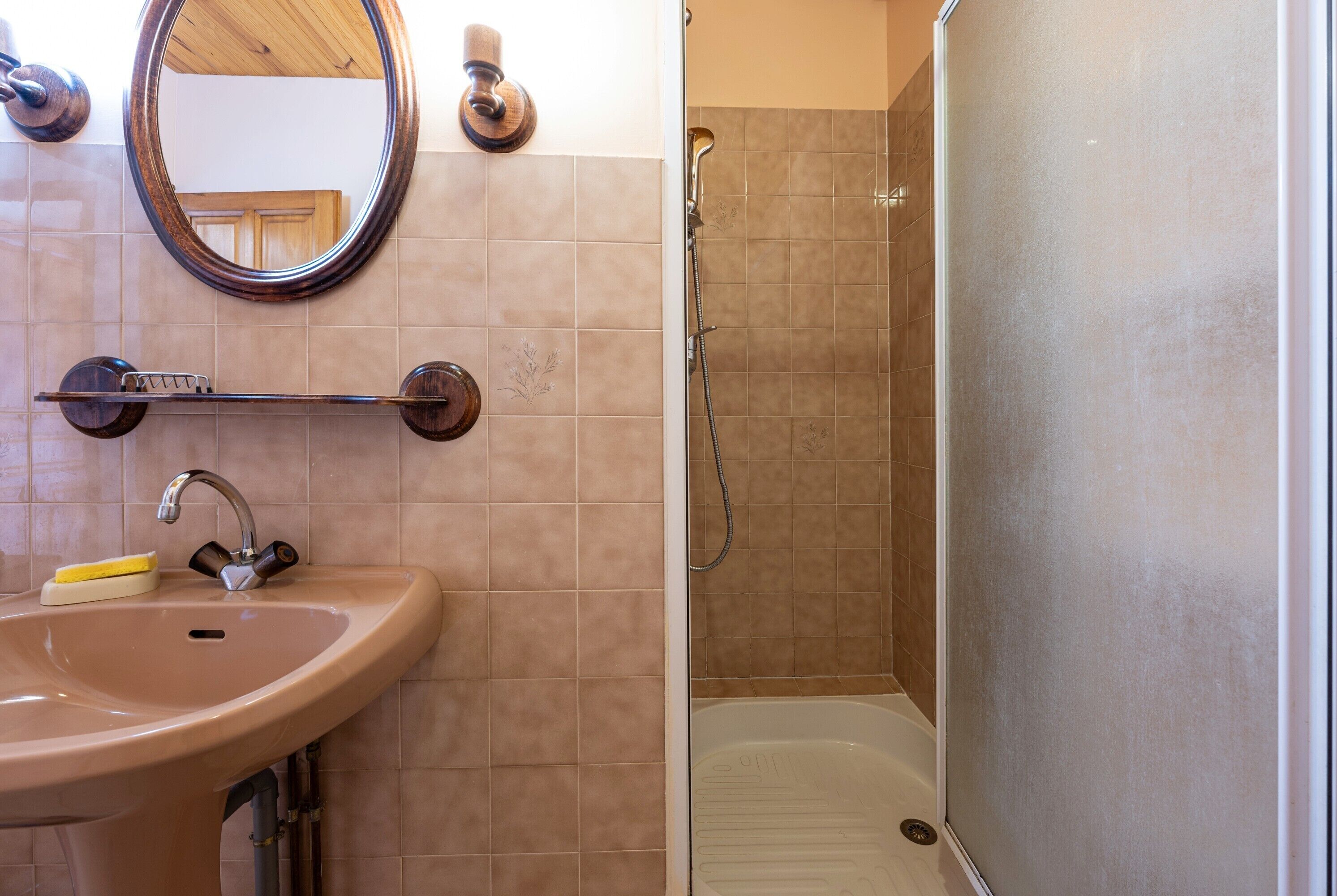 Une salle de bain avec un lavabo, un miroir et une douche.