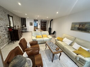 Un salon comprenant un canapé, des fauteuils, une table basse et une cheminée.