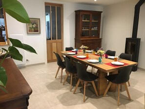 Un espace repas avec une table en bois dressée pour six personnes, entourée de chaises noires.
