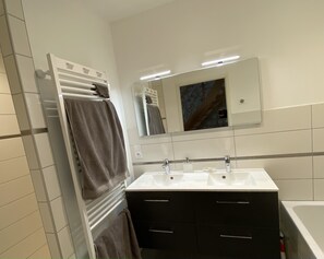 Ein Badezimmer mit Waschbecken, Spiegel und Handtuchhalter.