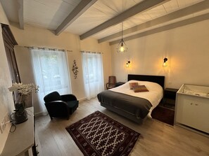 A bedroom with a bed, a chair, a desk, and a nightstand. - La Maison Du Tour De Ville, in the heart of Cajarc, walk everywhere, Wi-Fi and air conditioning (Cajarc)