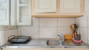 Une cuisine équipée d’une balance intégrée, d’un évier et de meubles de rangement en bois.