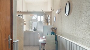 Un espace repas comprenant une table, des chaises et donnant sur la cuisine.