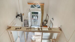 Une pièce avec un lit, un miroir, une fenêtre et une vue sur l’extérieur.