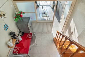 A kitchen with a red table, a coffee machine, and a plant. - Room 'Maisonette Two Split Level No 5' with Sea View, Wi-Fi and Air Conditioning (Panormos Kalymnos)