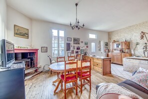 Un salon chaleureux avec une cheminée, une table à manger en bois et des sièges confortables.
