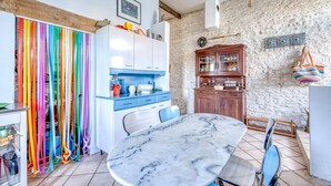 Une cuisine avec une table en marbre, des placards et un mur en pierre.