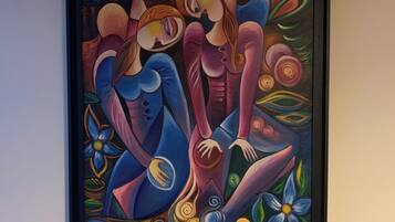 A framed abstract painting with geometric shapes and figures.