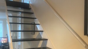 A modern staircase with black steps and a glass railing, leading to a lower level. - Perfect 2-bedroom house, Albert cottage with WiFi in charming Southampton (Southampton)