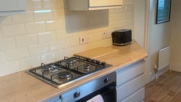 A kitchen with a gas stove, oven, and a toaster on the countertop.