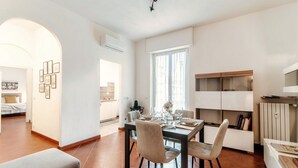 Uma cozinha moderna com uma mesa de jantar, cadeiras e vista para a sala de estar.