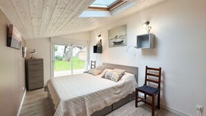 A bedroom with a bed, a chair, a desk, a shelf, and a skylight. - Pretty single-storey villa with garden (LA COUARDE SUR MER)