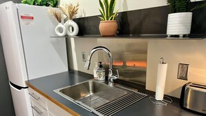 A modern kitchen with a stainless steel sink, a built-in oven, and a toaster. - Boho Haven with Free Parking, Wifi and King Bed, Walk to Clubs, U of A and Food (Tucson)