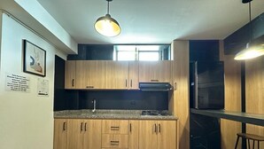 A modern kitchen with wooden cabinets, a granite countertop, and a built-in oven. - Luxury apt with jacuzzi near downtown  (Santa Rosa de Cabal)