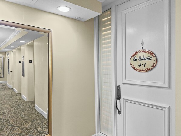 Building hallway showing unit entrance door with personalized decorative signage