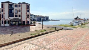 Un bâtiment situé sur la côte, doté d’une cour pavée, d’un petit espace couvert et offrant une vue sur la mer.
