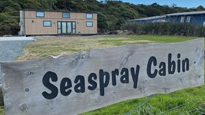 A wooden sign with "Seaspray Cabin" written on it, indicating the name of the cabin.