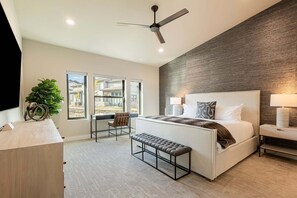 A modern hotel room with a large bed, a desk, a chair, a bench, a ceiling fan, and a view of the outside. - Deer Valley East Village, Free Ski Shuttle, Near the Lake, Private Hot Tub (Heber City)