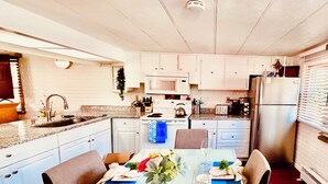 Une cuisine moderne avec des armoires blanches, un comptoir en granit et des appareils électroménagers en acier inoxydable.