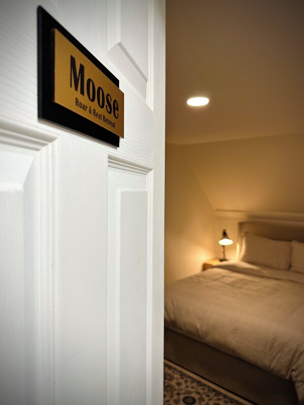 Ein Hotelzimmer mit einem Schild auf der Tür, das "Moose Roar & Rest Retreat" zeigt.