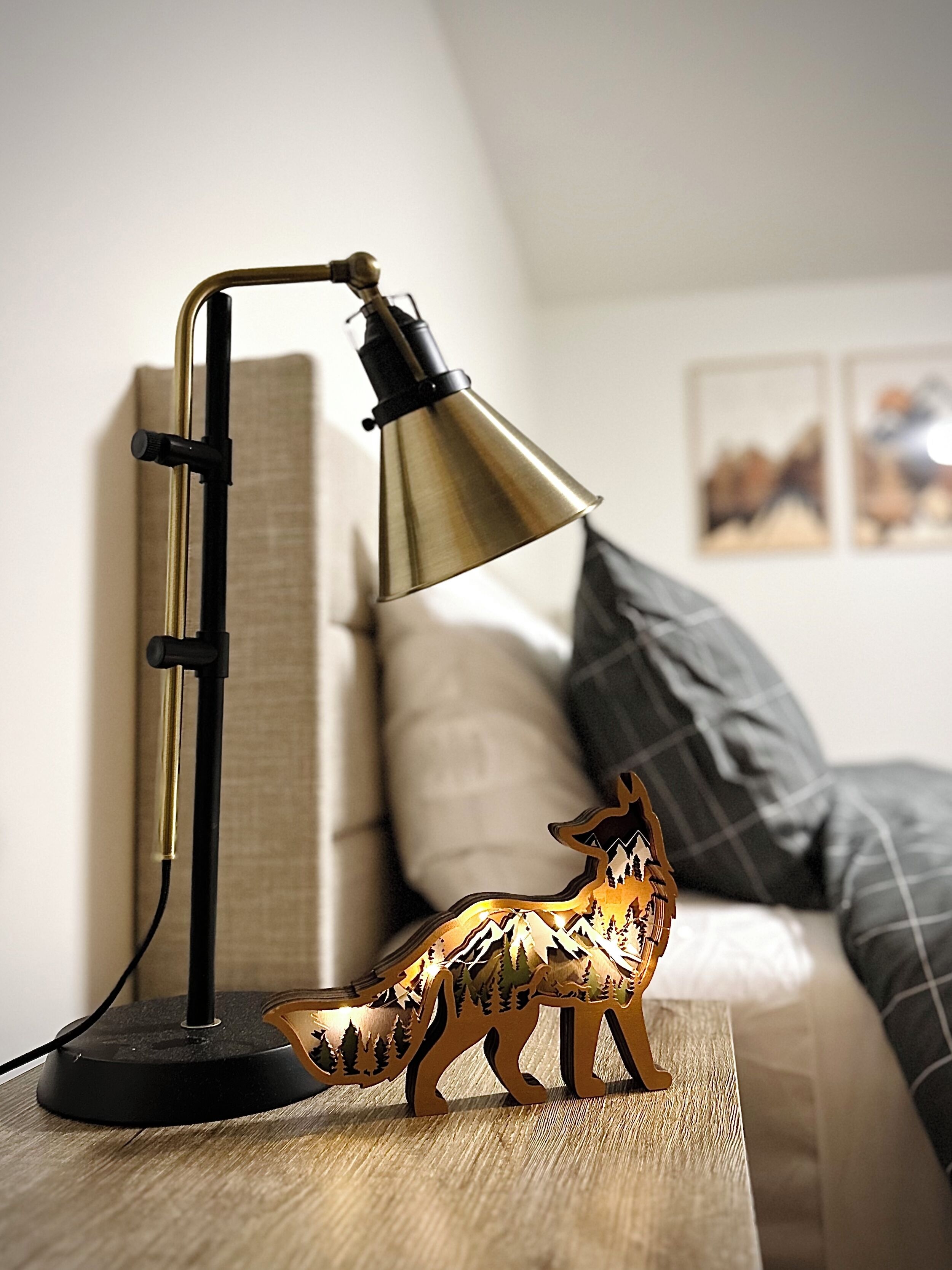 En lampa står på ett sidobord bredvid en liten träfigur föreställande en räv.