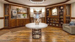 A hotel lobby with a round table, wooden bookshelves, a sofa, and a ceiling light fixture. - Abode at Silver Summit, ski-in/ski-out, hot tub, pool table, Silver Lake (Park City)