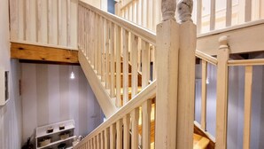 A wooden staircase with a white railing leading to an upper floor. - La Curuxa House in Vidiago, Llanes (Vidiago)
